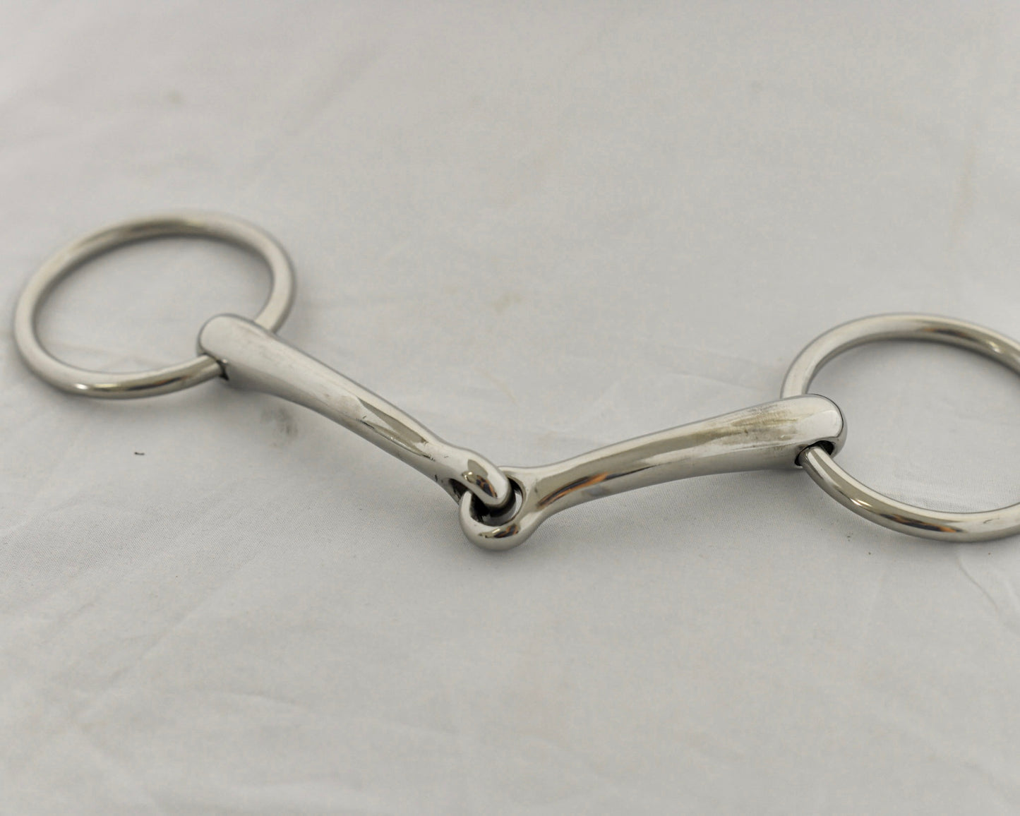 Close up of badroon gag horse bit on a white surface.