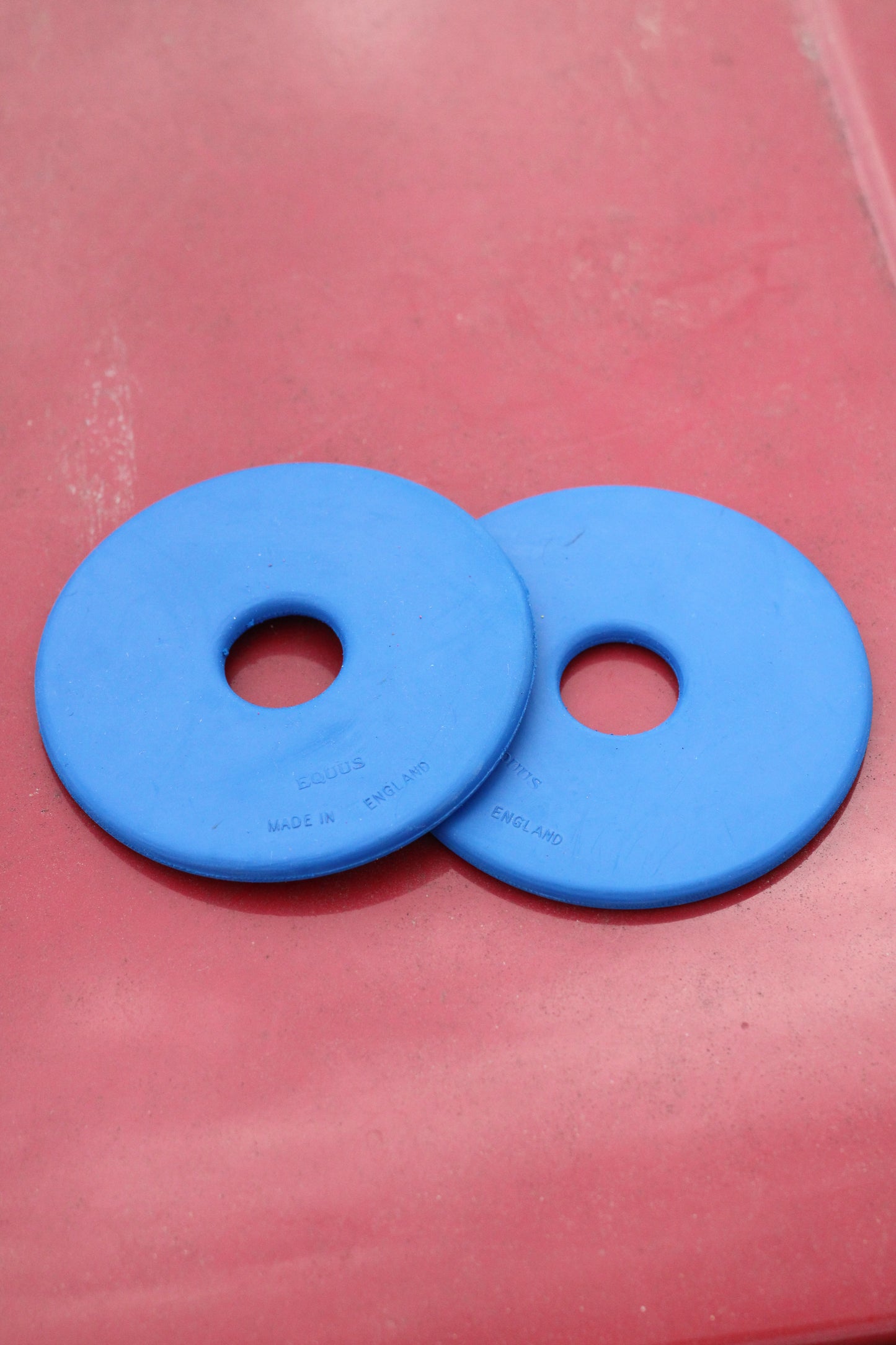 Two blue bit guards sitting on a red surface.