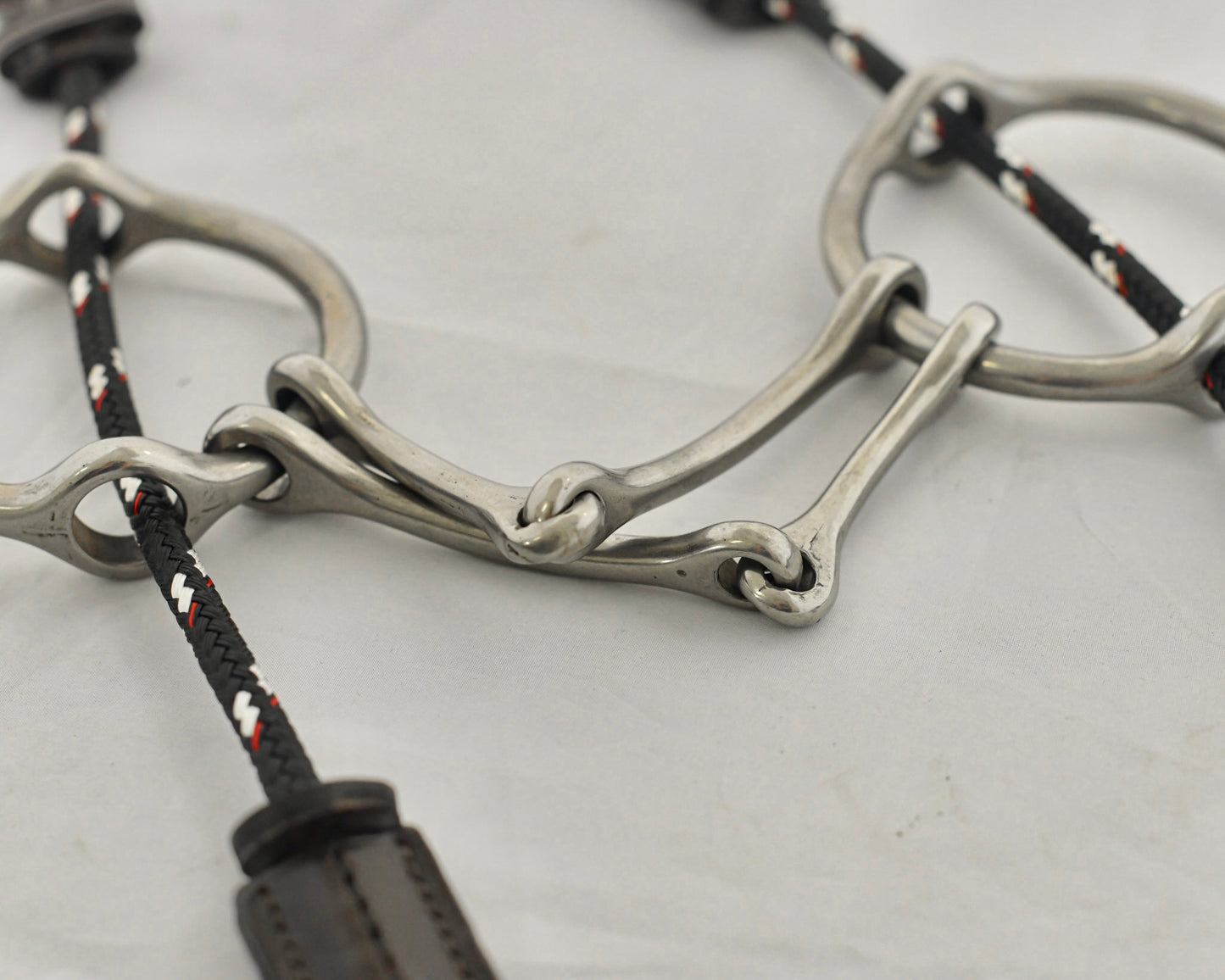Close up of plain barry gag horse bit on a white surface.
