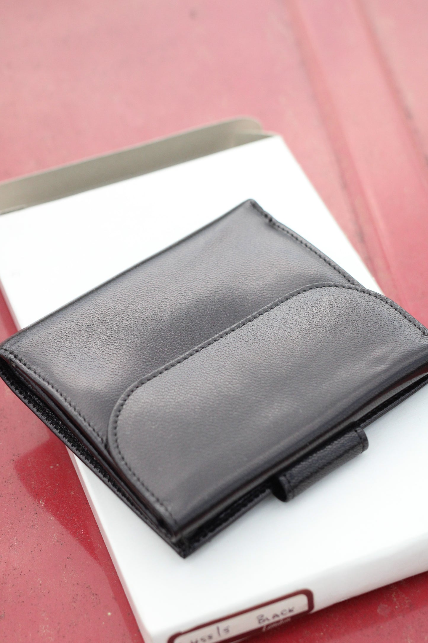 Leather bifold wallet with wide snap closure closed.