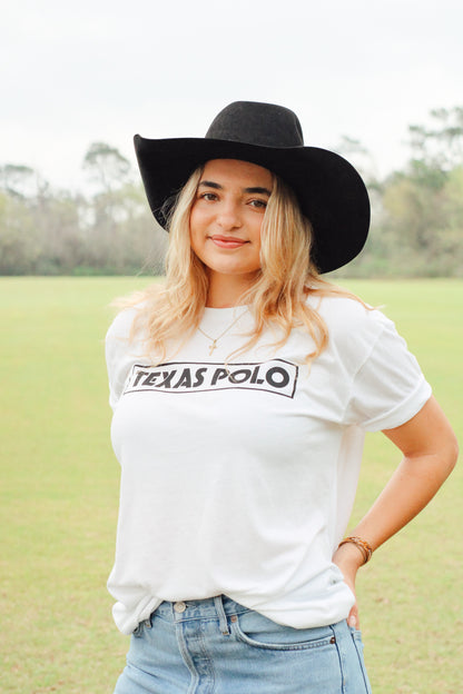 Girl wearing white t-shirt with black Texas Polo logo and a black cowboy hat.