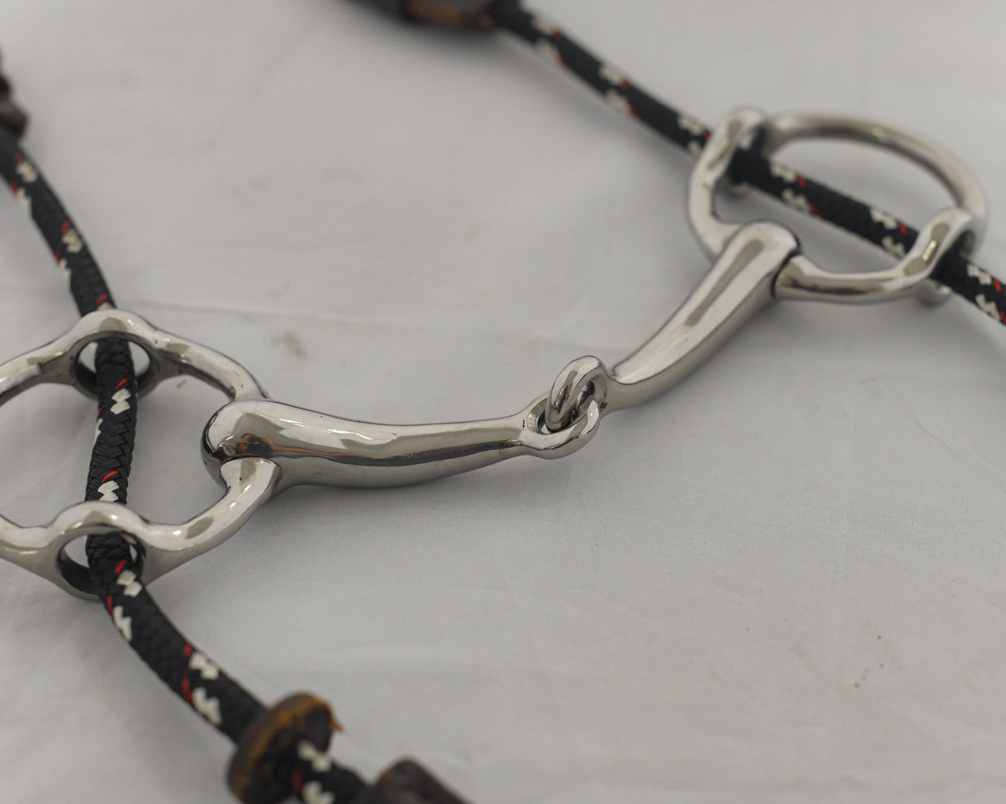 Close up of a 4 inch ring gag horse bit on a white surface.