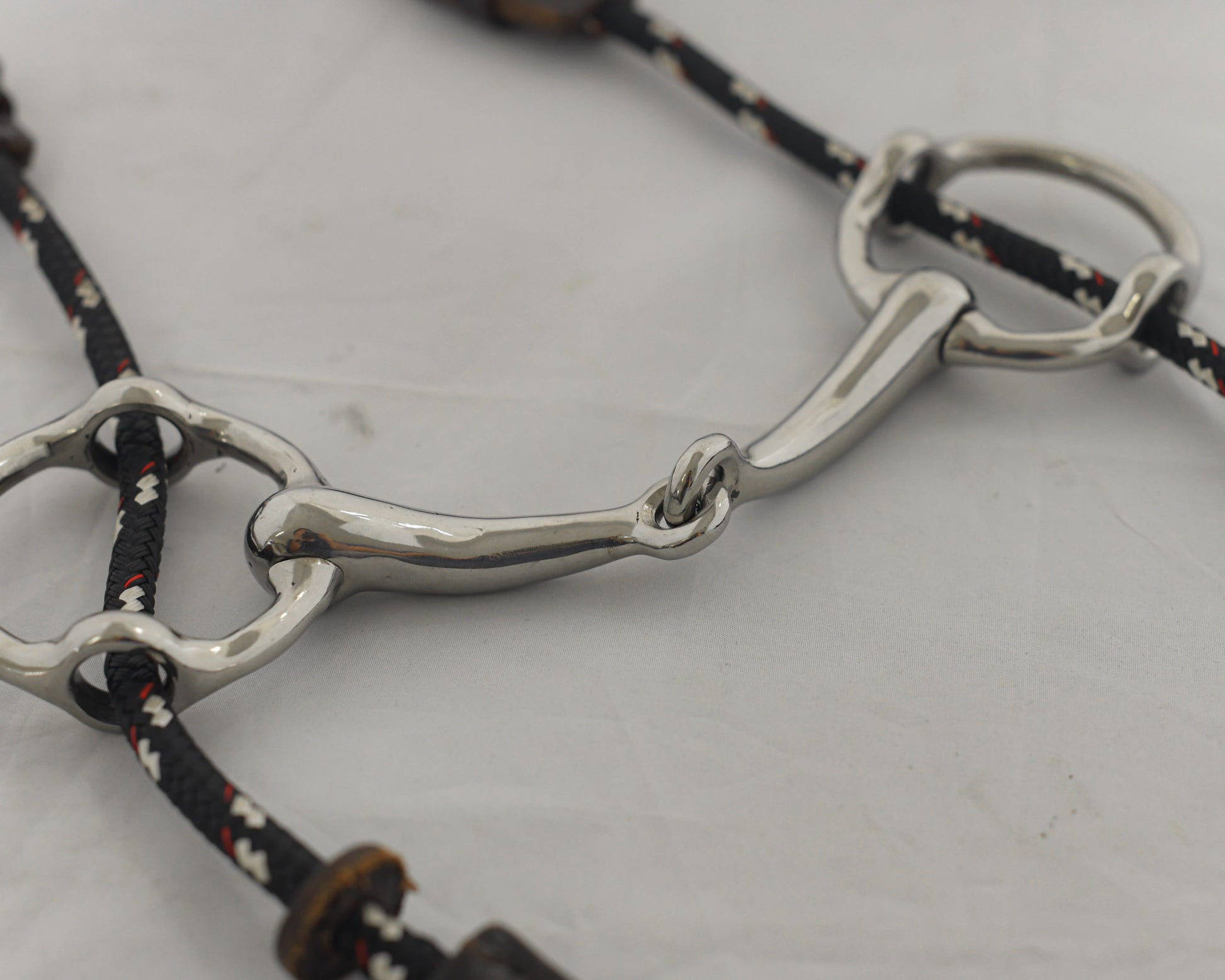 Close up of a 4 inch ring gag horse bit on a white surface.