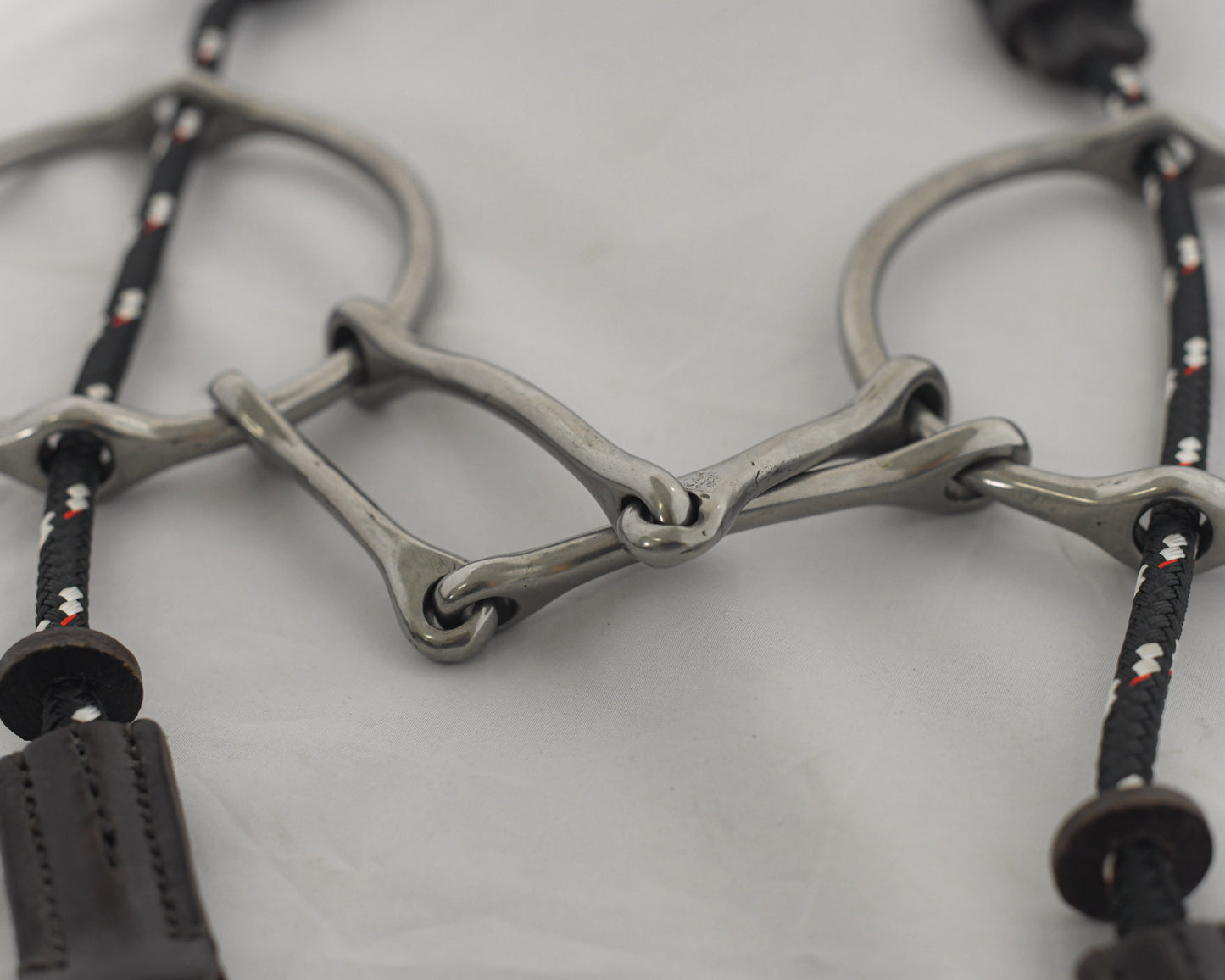 Close up 5 inch ring gag horse bit on a white surface.