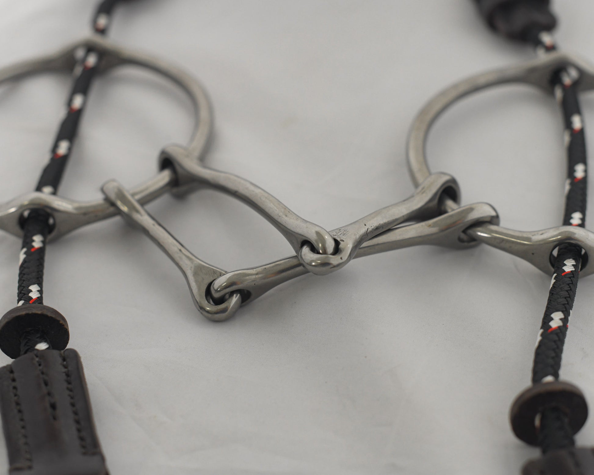 Close up 5 inch ring gag horse bit on a white surface.