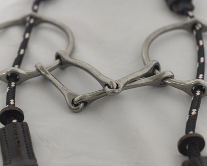 Close up 5 inch ring gag horse bit on a white surface.