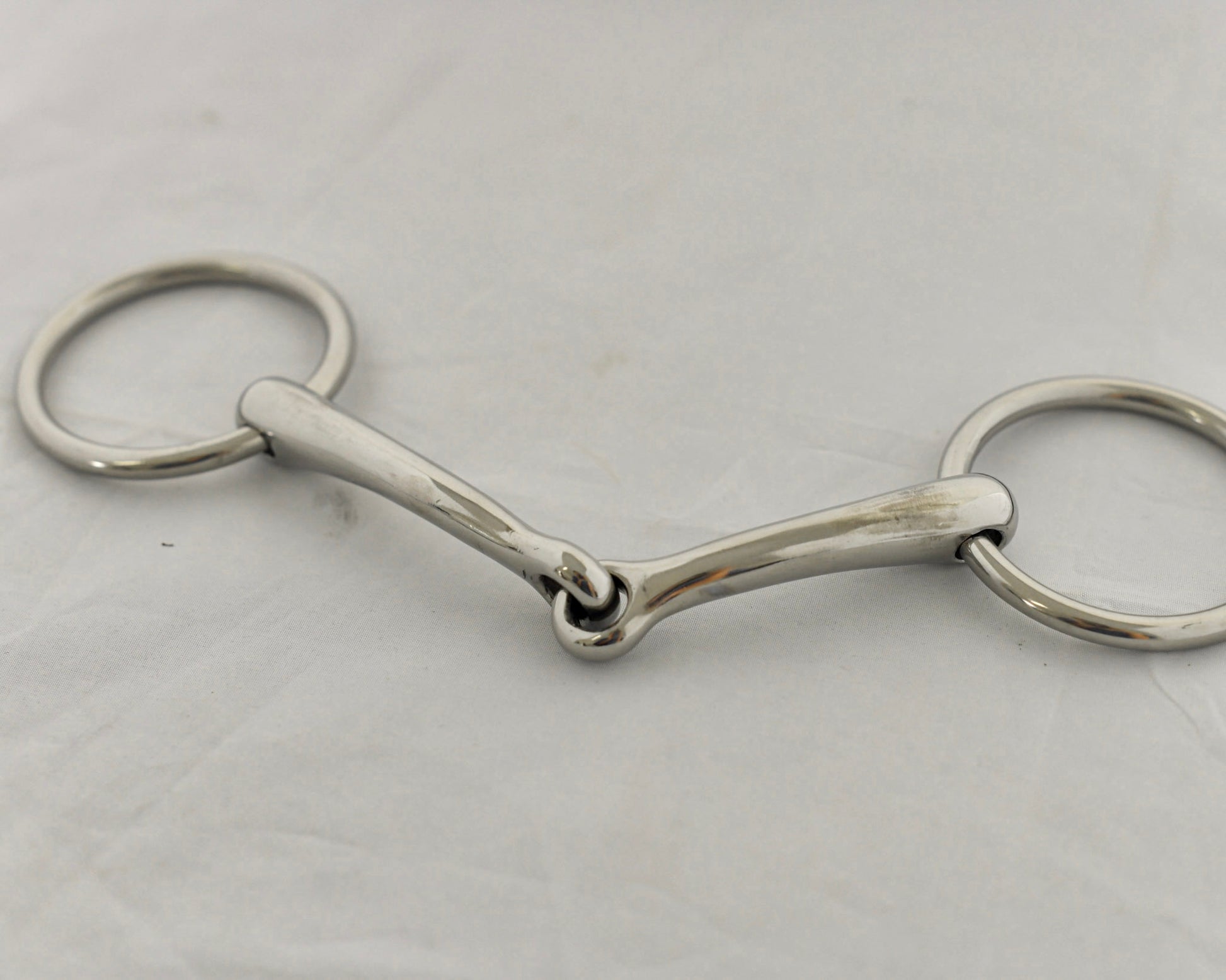 Close up of badroon gag horse bit on a white surface.