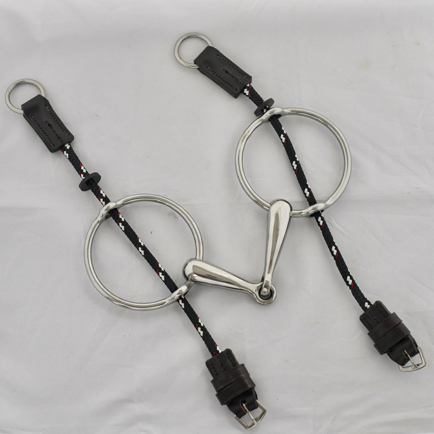 Big ring gag horse bit on a white surface.