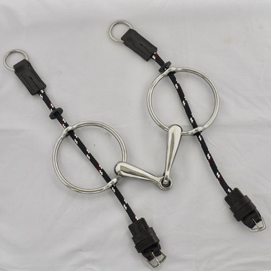 Big ring gag horse bit on a white surface.