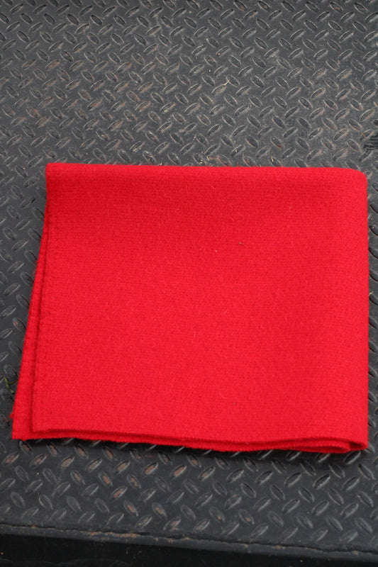 Red folded horse blanket sitting on a black surface.