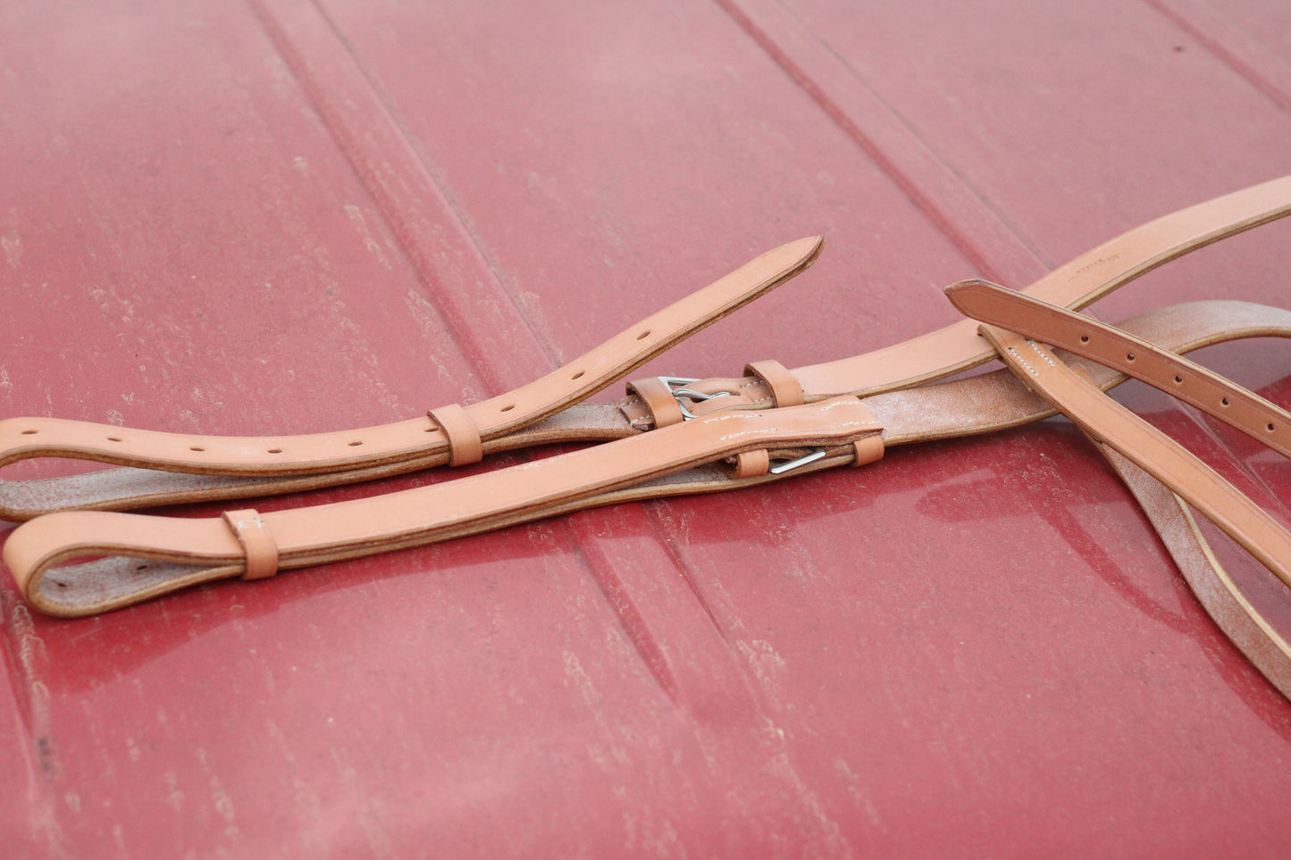 Leather breastplate sitting on a red surface.