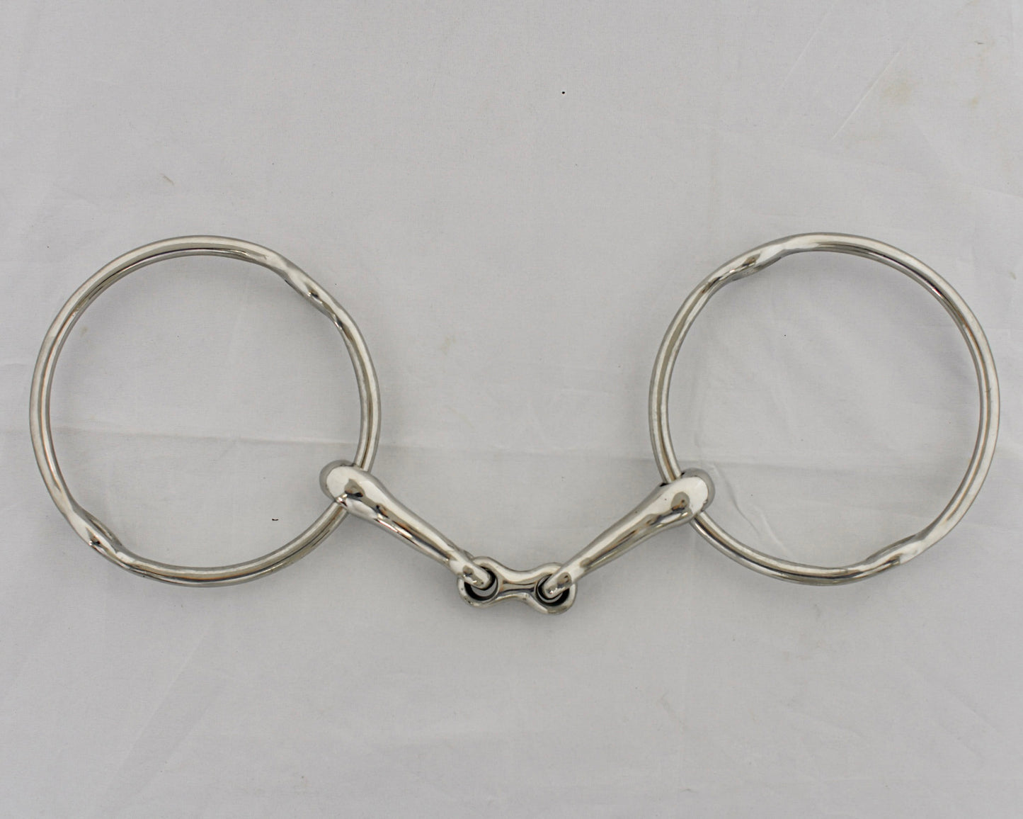 Center link gag horse bit on a white surface.