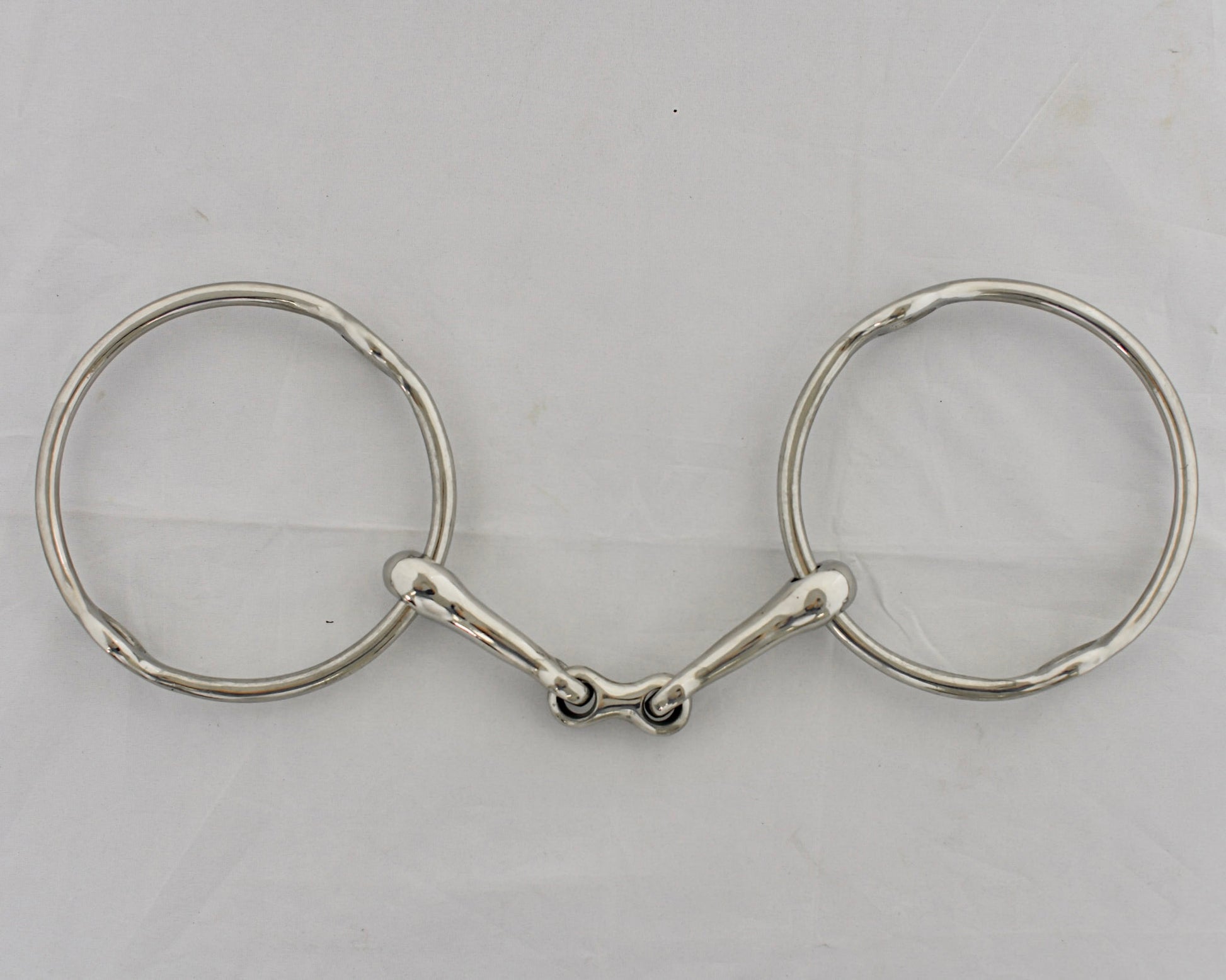Center link gag horse bit on a white surface.