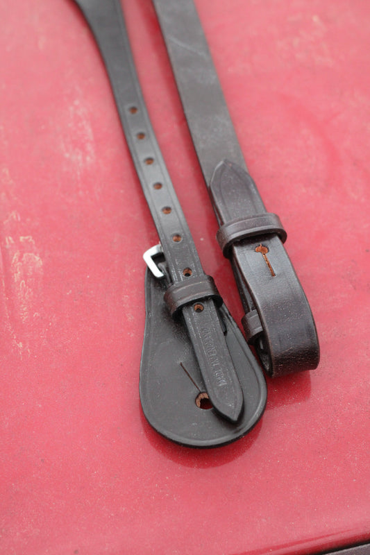 Close up of cheeks buckles on a red surface.