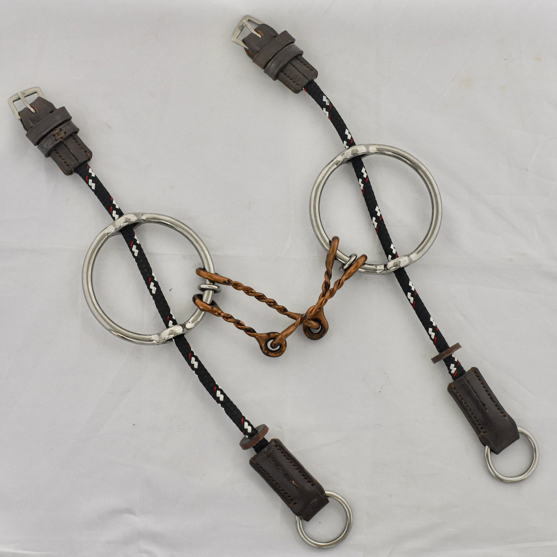 Copper twist barry gag horse bit on a white surface.