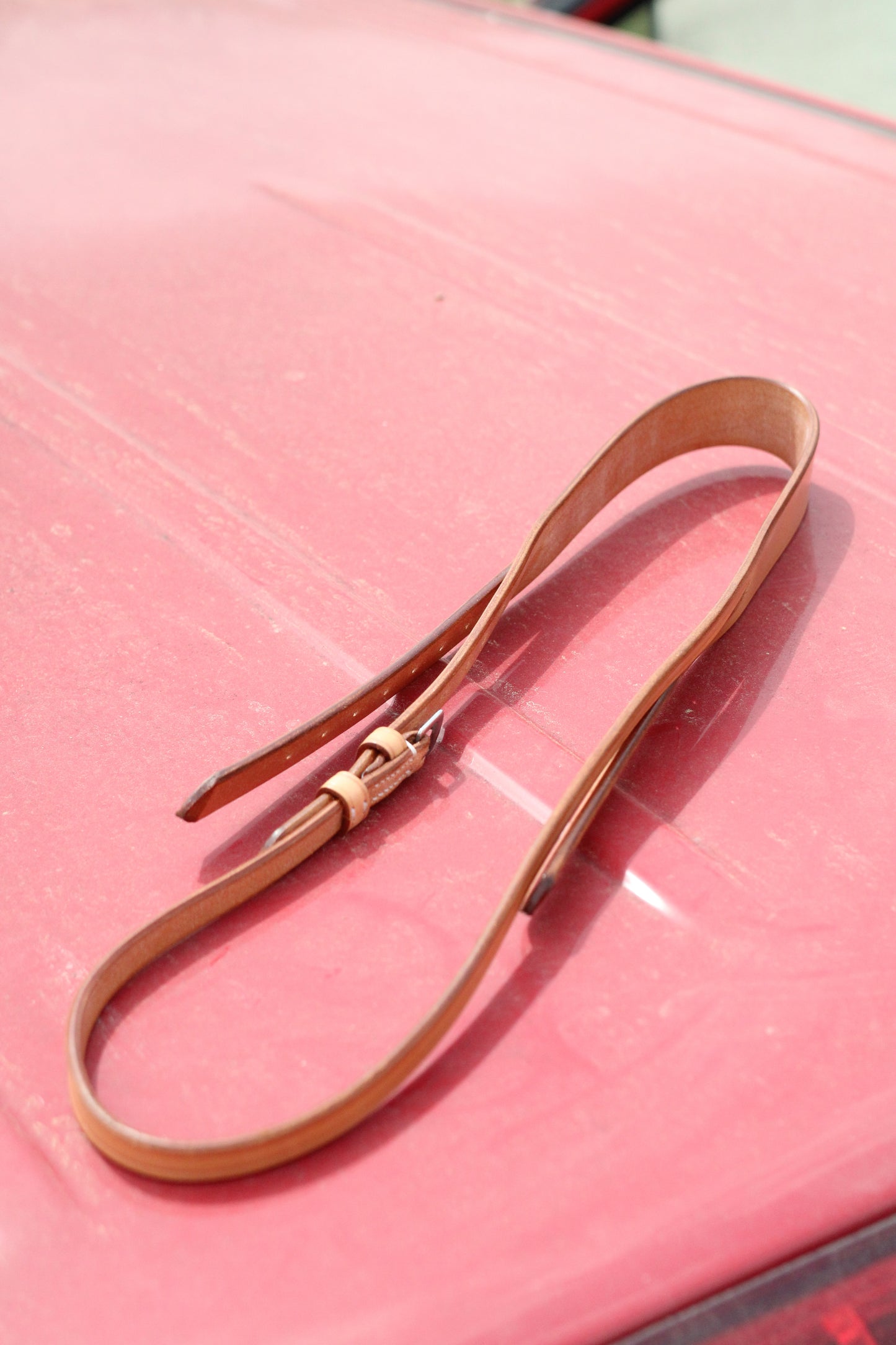 Top view of tan leather crown piece sitting on a red surface.