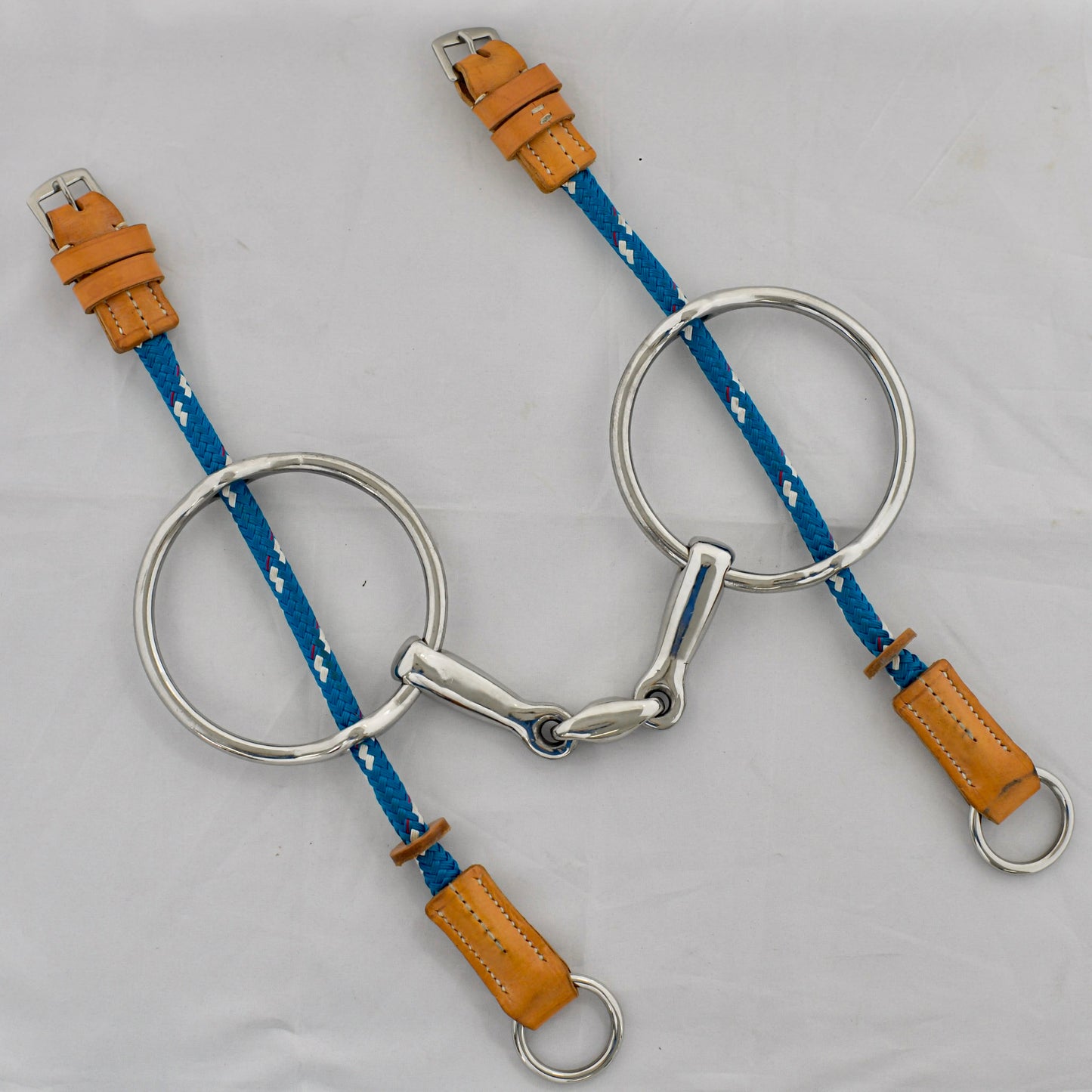 Egg link gag horse bit on a white surface.