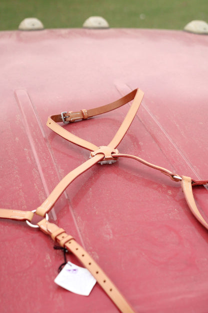 Close up of tan leather figure 8 mouth tie on a red surface.