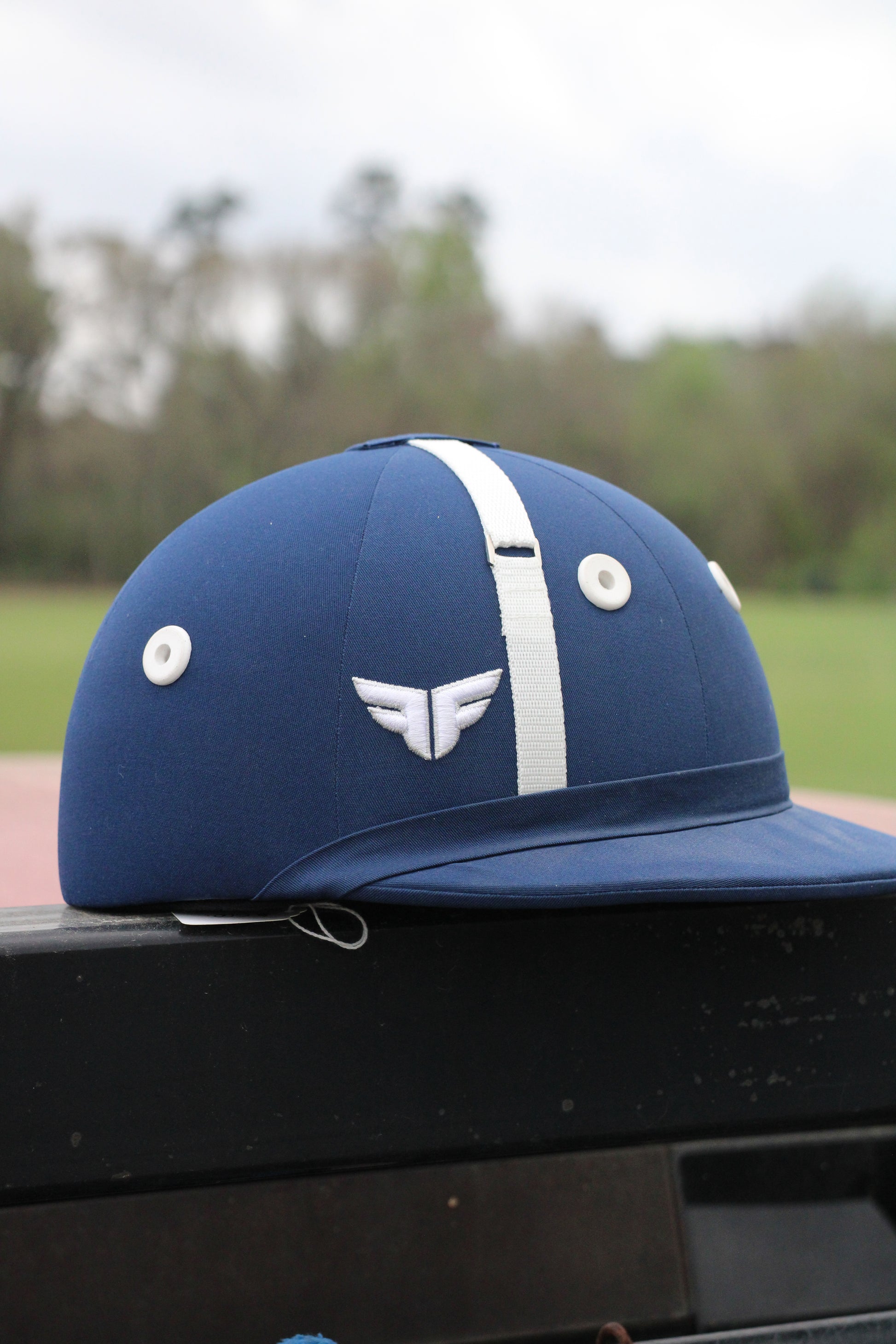 Blue helmet with white accents sitting on a black surface.
