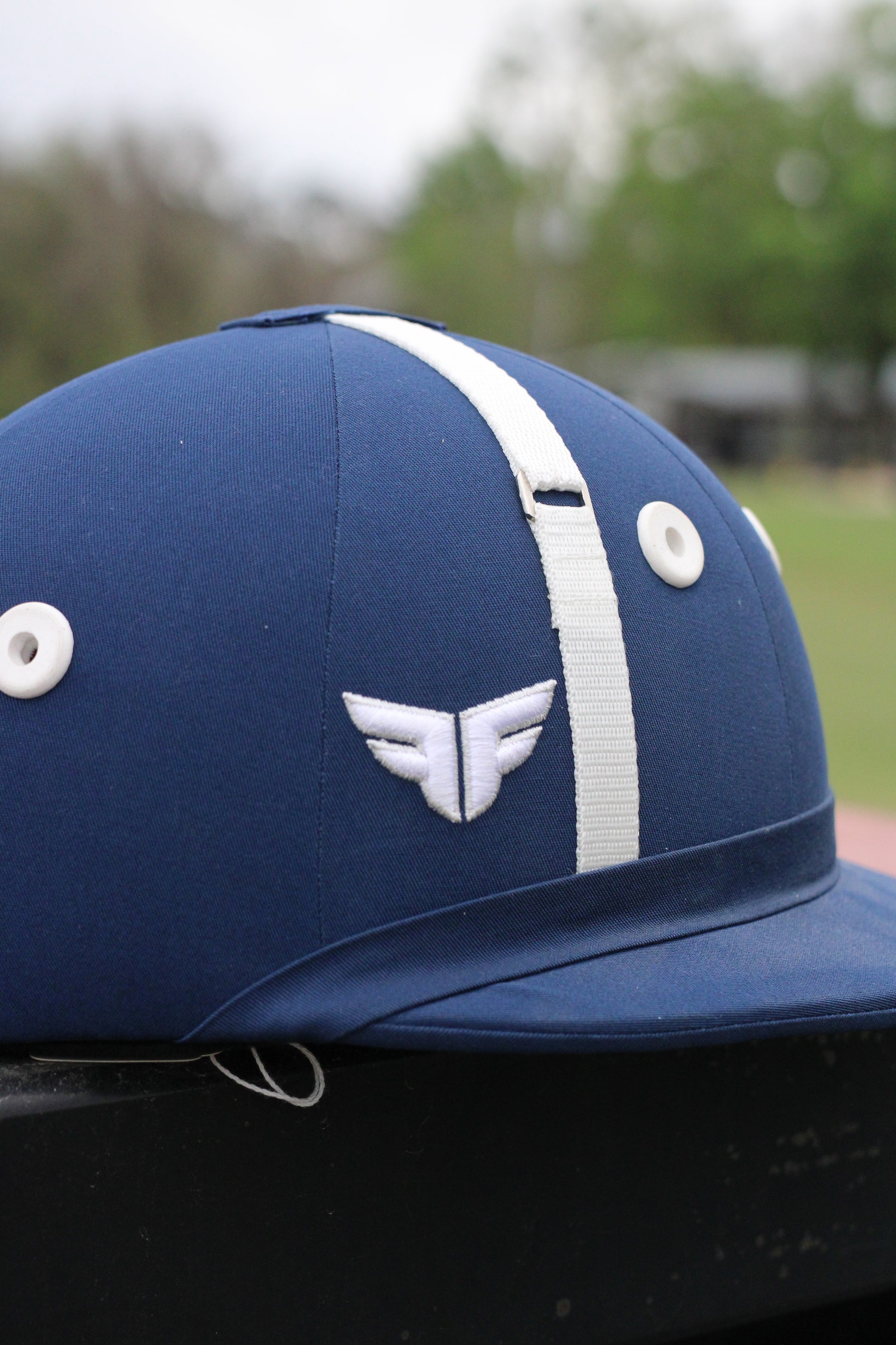 Close up of blue helmet with white accents sitting on a black surface.