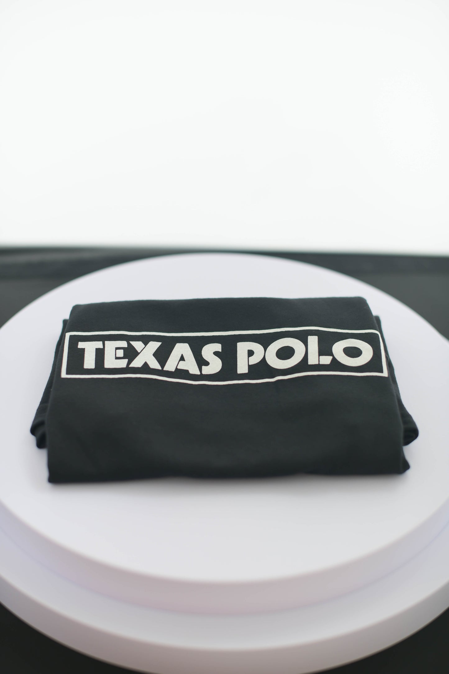 Folded black Texas Polo t-shirt.