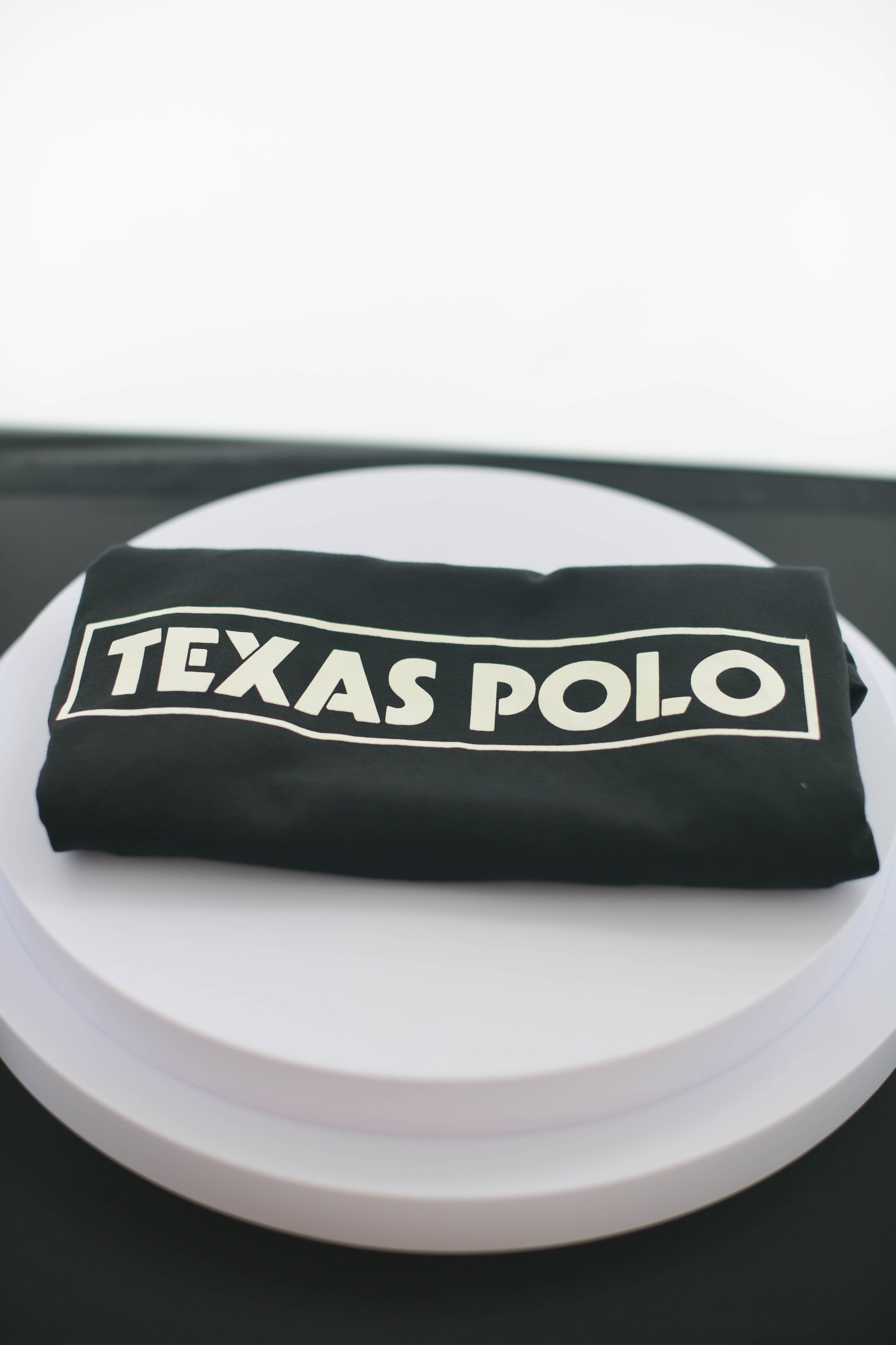 Folded black Texas Polo tshirt.