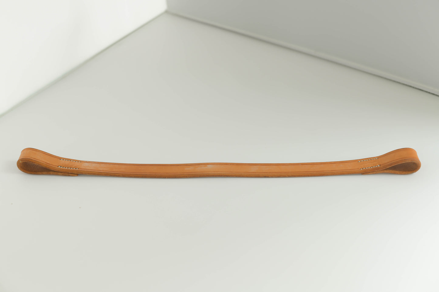 Leather brow band on a white surface.