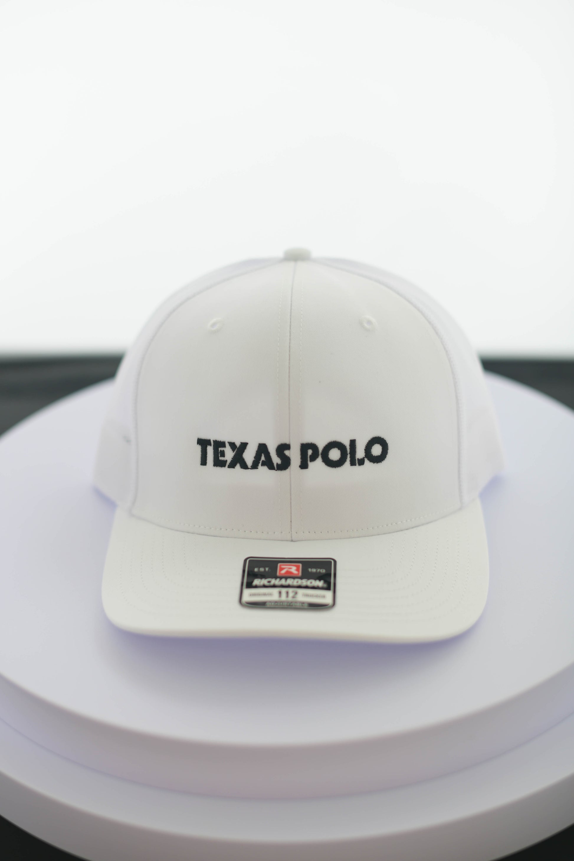 White Texas Polo cap on a white surface.
