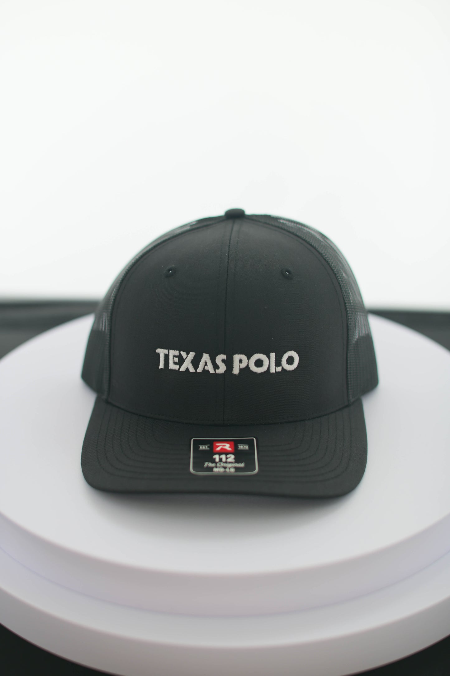 Black Texas Polo cap on a white surface.