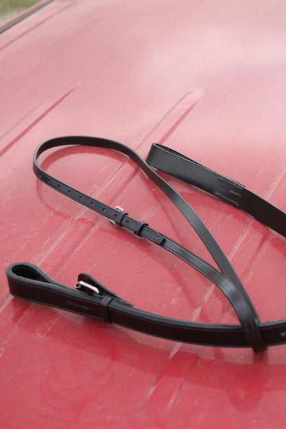 Leather martingale on a red surface.
