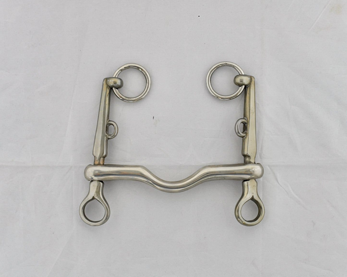 Pelham horse bit on a white surface.