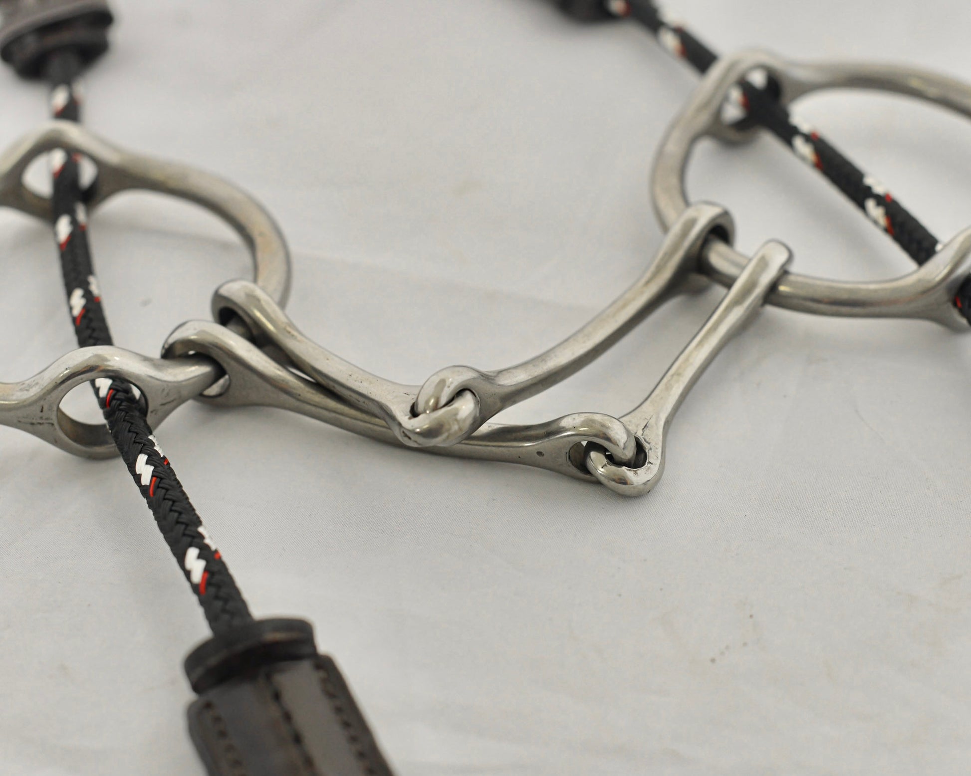 Close up of plain barry gag horse bit on a white surface.