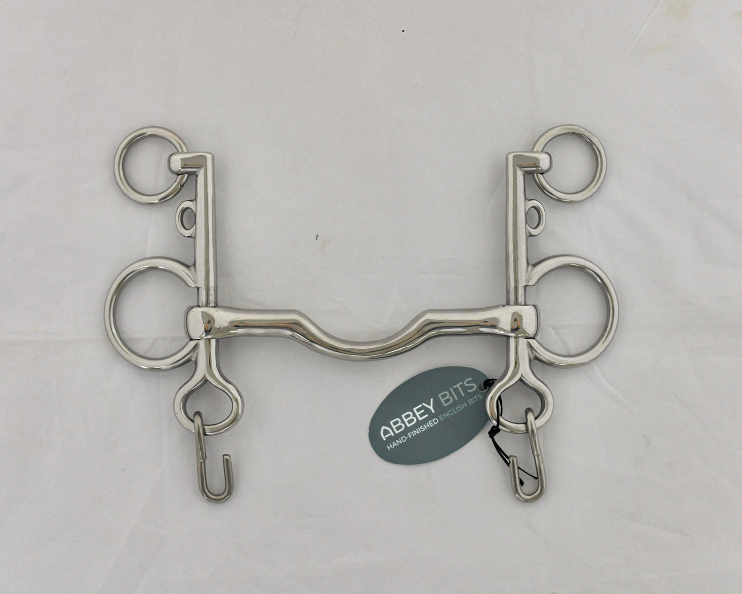 Ported pelham horse bit on a white surface.