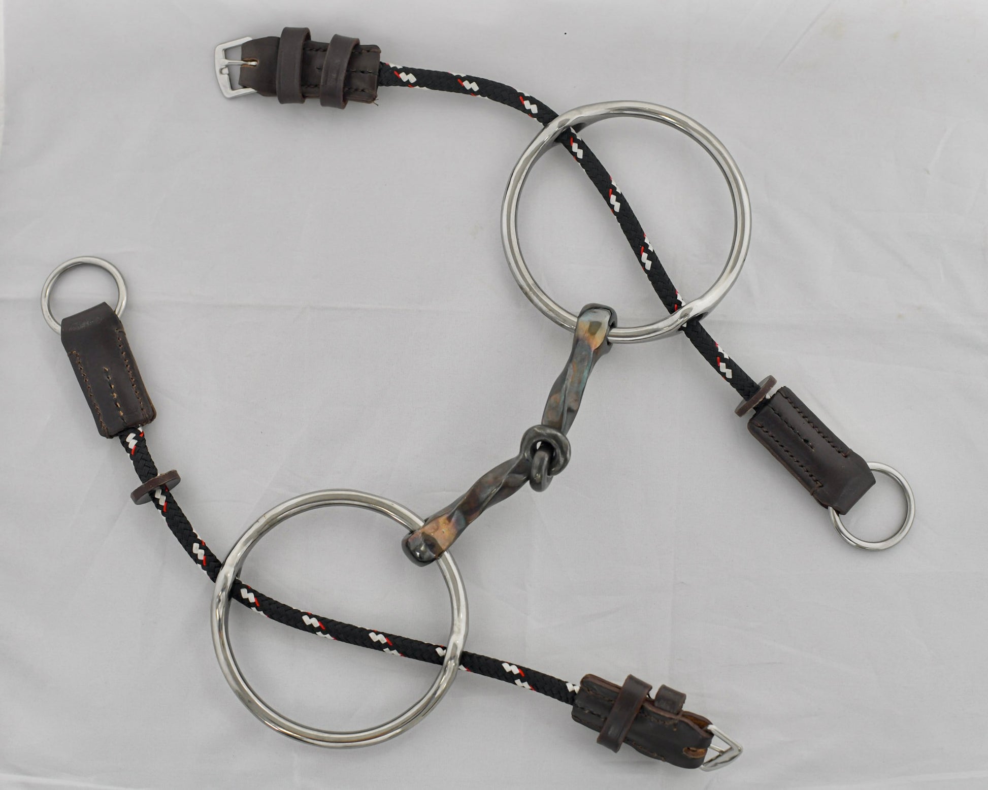 Slow twist copper mouth gag horse bit on a white surface.
