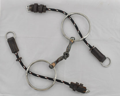 Slow twist copper mouth gag horse bit on a white surface.