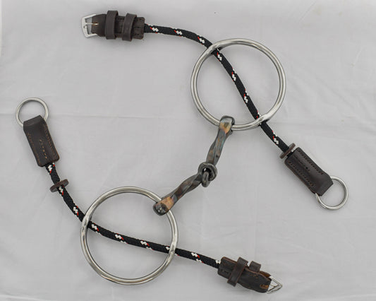 Slow twist copper mouth gag horse bit on a white surface.