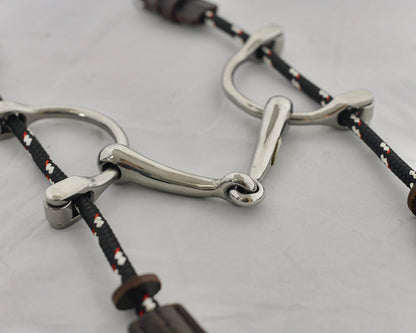 Close up of small balding gag horse bit on a white surface.