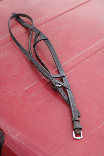 Brown leather Texan dropnose band sitting on a red surface.