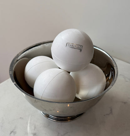 White Texas Polo branded polo balls sitting in a metal bowl.