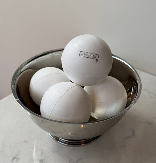 White Texas Polo branded polo balls sitting in a metal bowl.