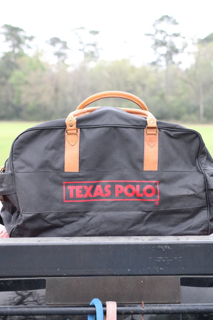 Front view of black travel bag with red Texas Polo logo and tan leather handles.