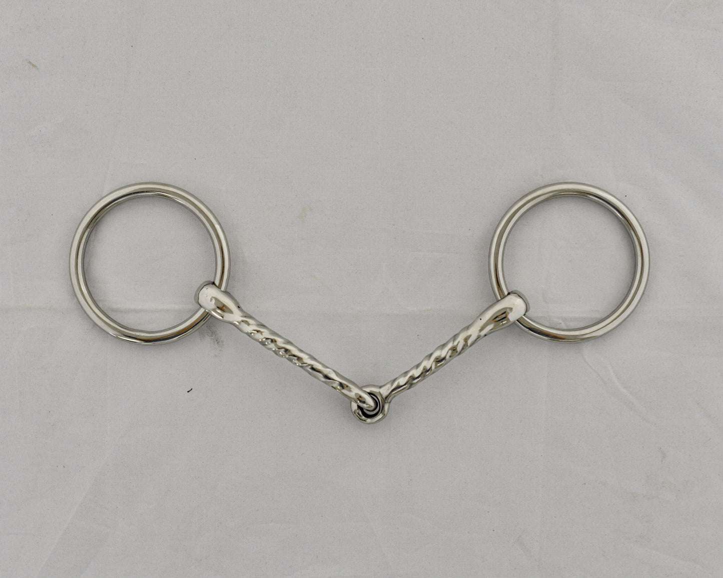 Twisted badroon gag horse bit on a white surface.