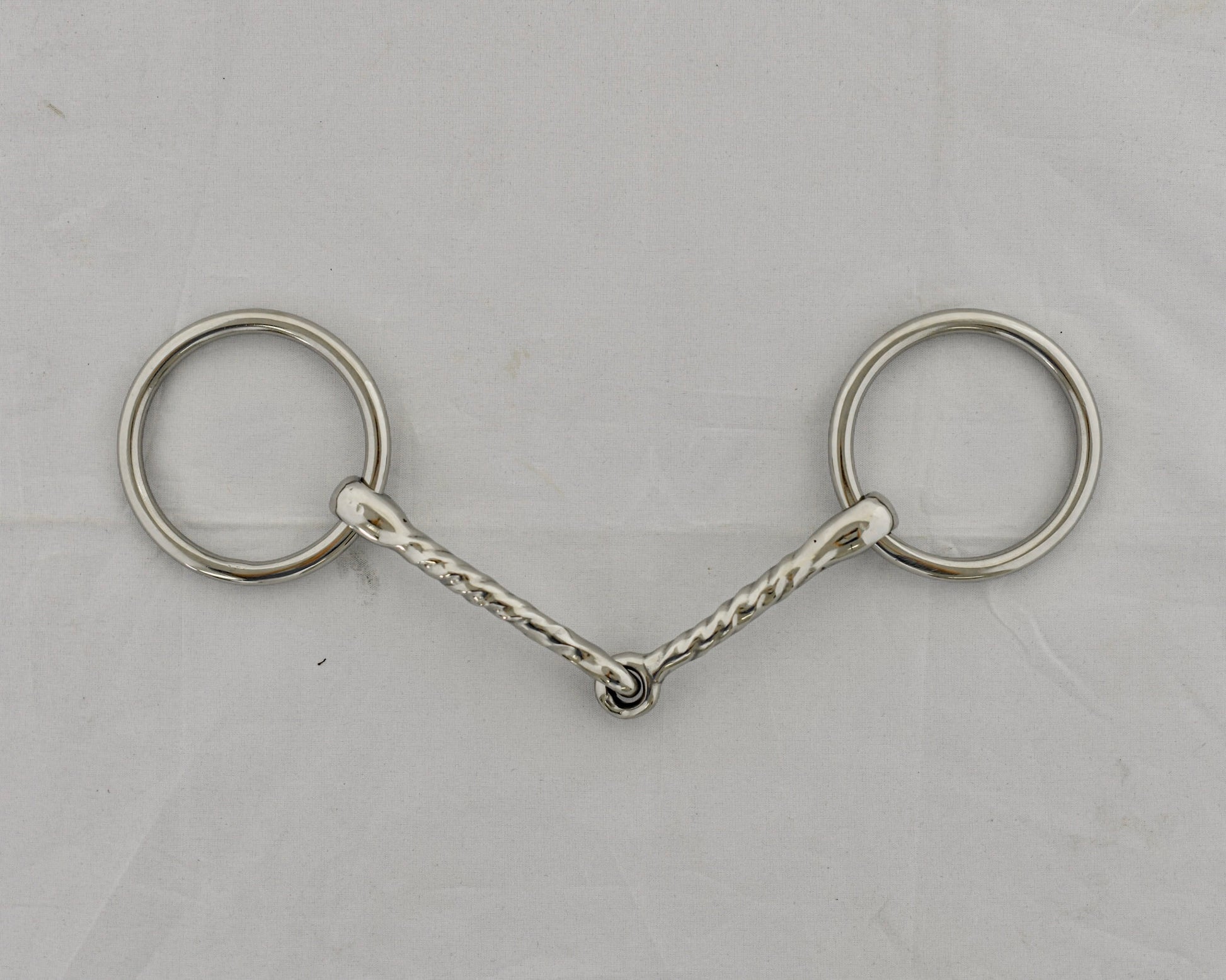 Twisted badroon gag horse bit on a white surface.