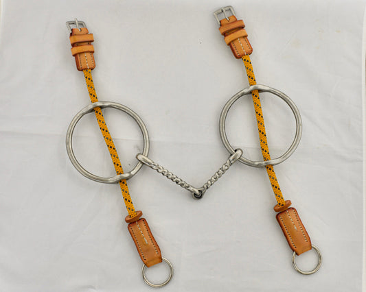 Twisted big ring gag horse bit on a white surface.