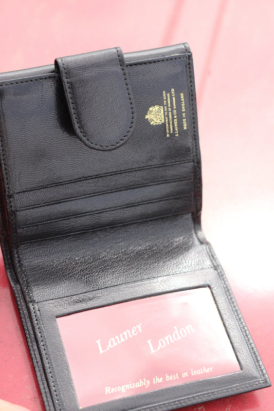 Leather bifold wallet with small snap closure opened face up.