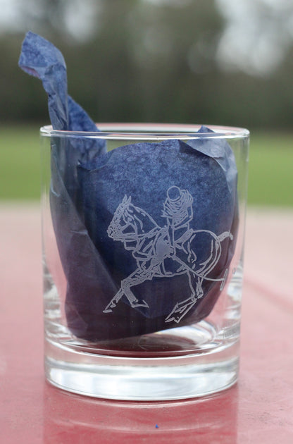 Front view of whiskey glass with polo graphic, with navy tissue paper inside.