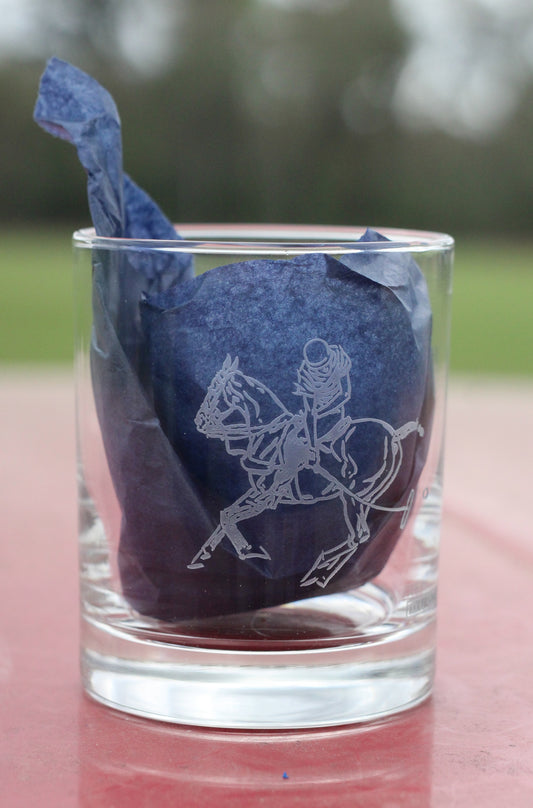 Front view of whiskey glass with polo graphic, with navy tissue paper inside.